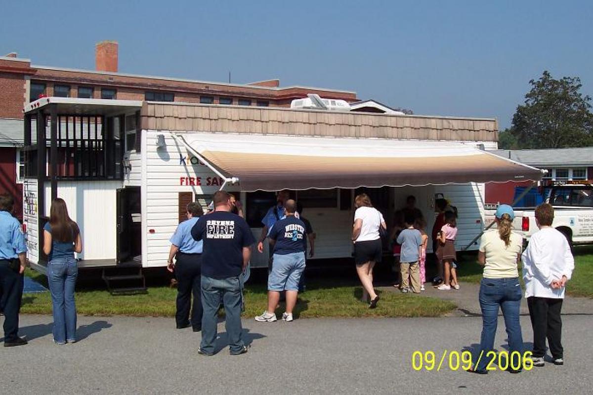 People Line up in Front of a Fire Safety Trailer